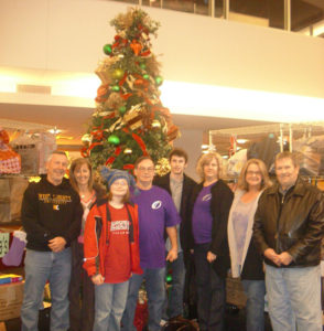 A group of people standing in front of a Christmas tree