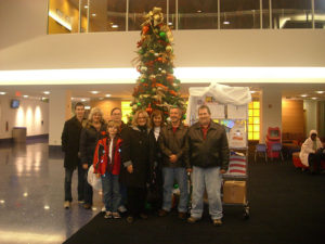 People standing in front of a Christmas tree in a lobby
