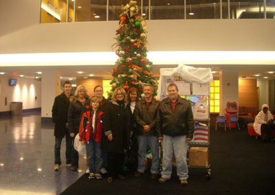 People standing in front of a Christmas tree in a lobby